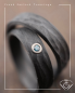 Preview: Trauringe aus Carbon mit Rinde-Oberfläche und blauem Diamant