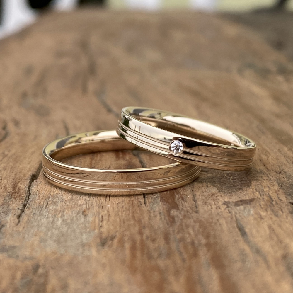 Preview: Eheringe aus 585 Caramelgold mit Glanzrillen, polierter Oberfläche und Brillant