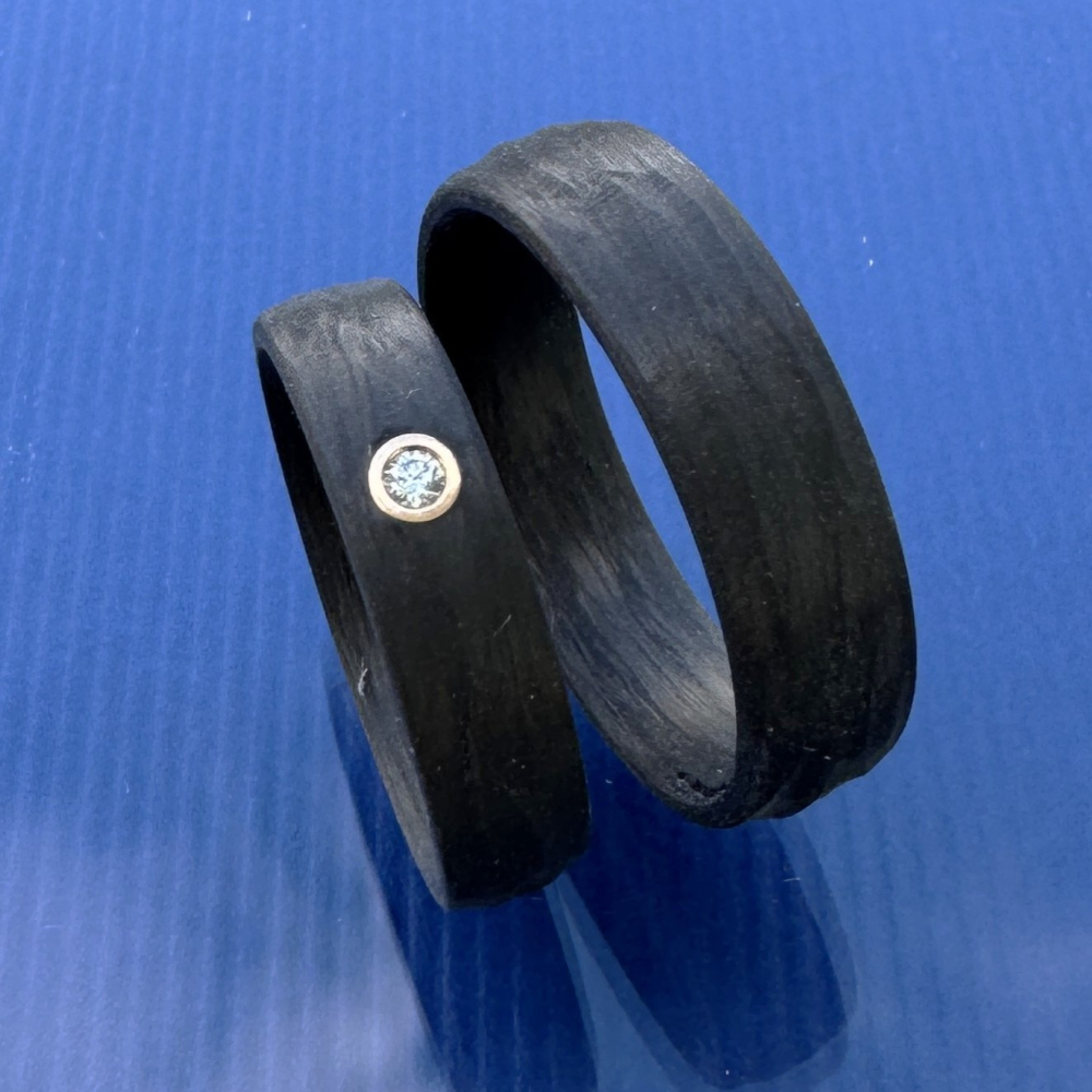 Preview: Trauringe aus Carbon mit Rinde-Oberfläche und Caramelgold-Fassung