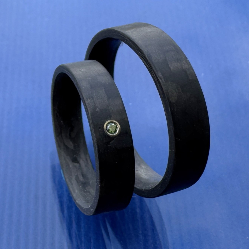 Preview: Trauringe aus Carbon mit glatter Oberfläche und blauem Diamant