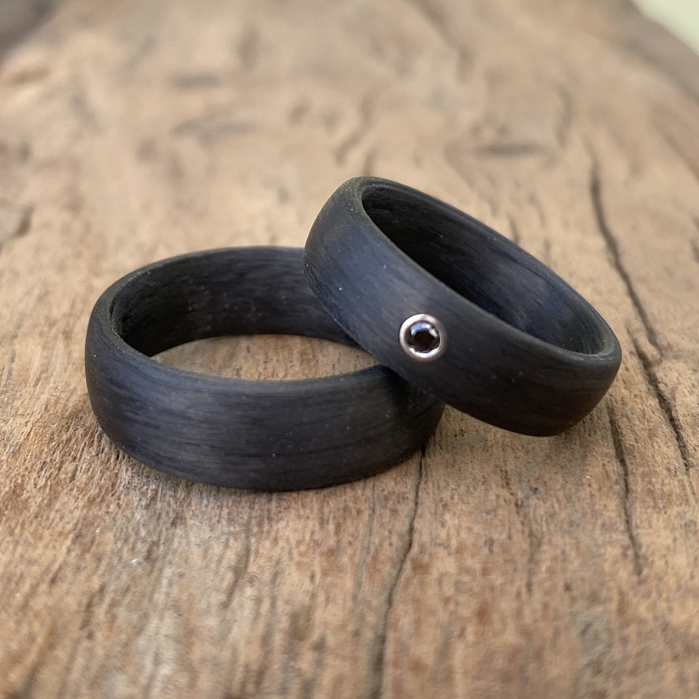 Trauringe aus Carbon mit glatter Oberfläche und schwarzem Diamant