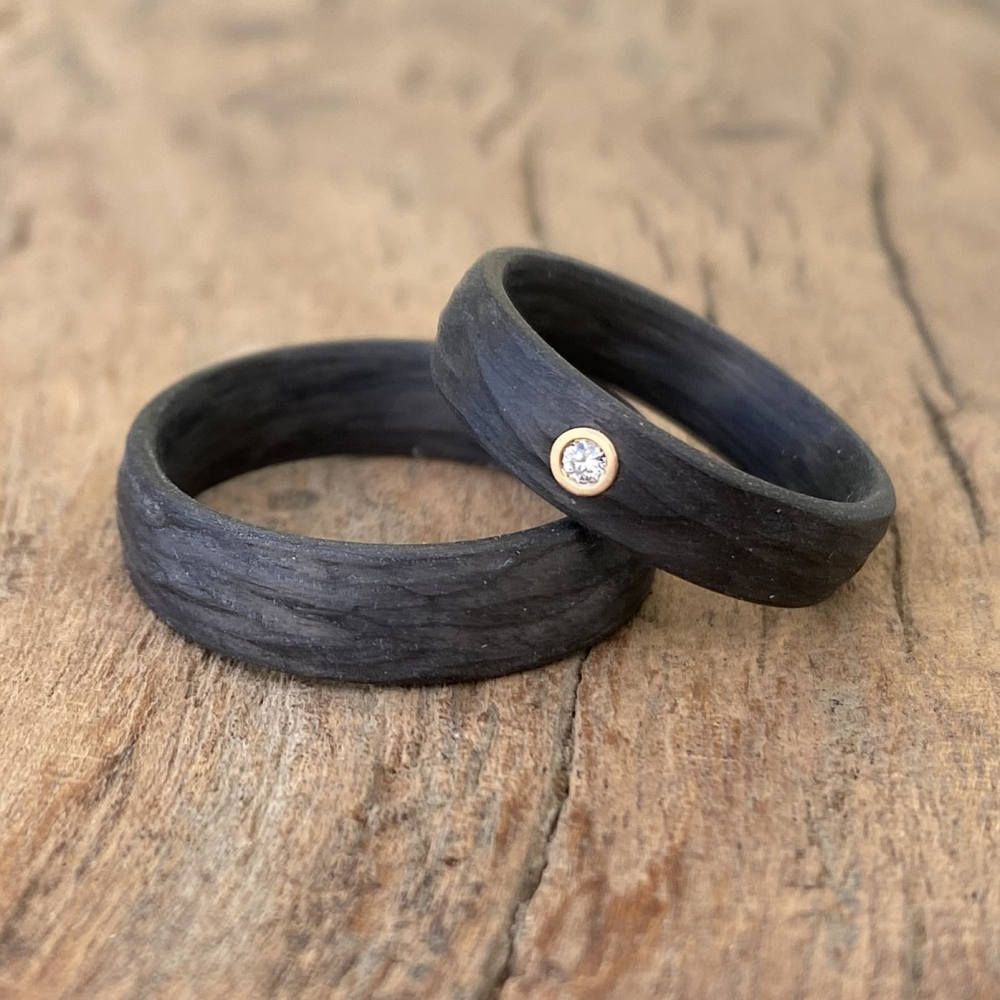 Trauringe aus Carbon mit Rinde-Oberfläche und Caramelgold-Fassung