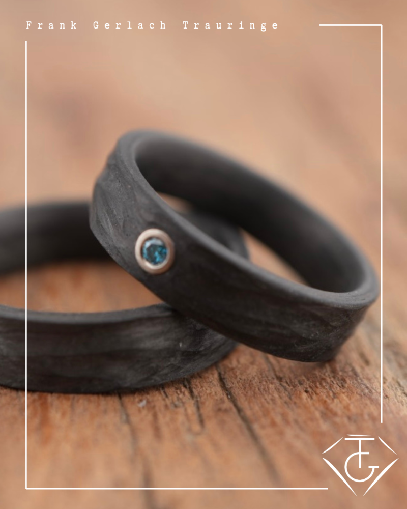 Preview: Trauringe aus Carbon mit Rinde-Oberfläche und blauem Diamant