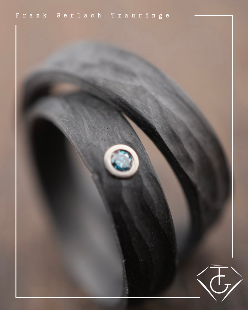 Preview: Trauringe aus Carbon mit Rinde-Oberfläche und blauem Diamant