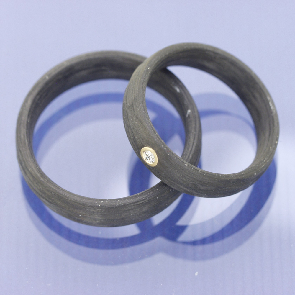 Preview: Trauringe aus Carbon mit Rinde-Oberfläche und Caramelgold-Fassung